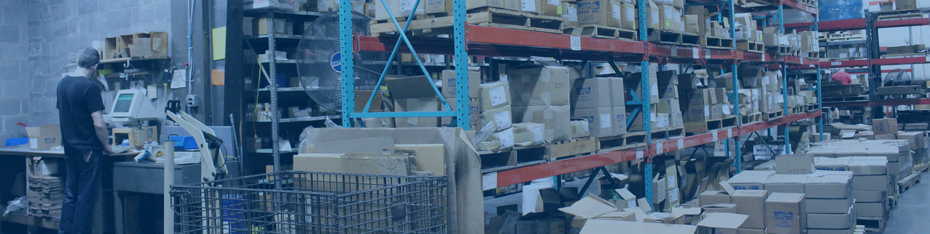 an ISSCO worker on the computer in the warehouse